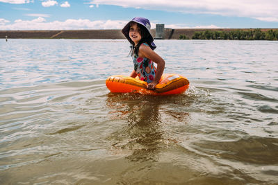 Young girl playing in lake alone