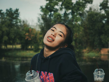 Portrait of smiling mid adult man against lake