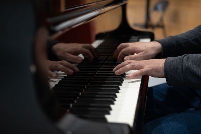 Midsection of man playing piano