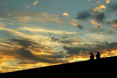 Silhouette of built structure against cloudy sky