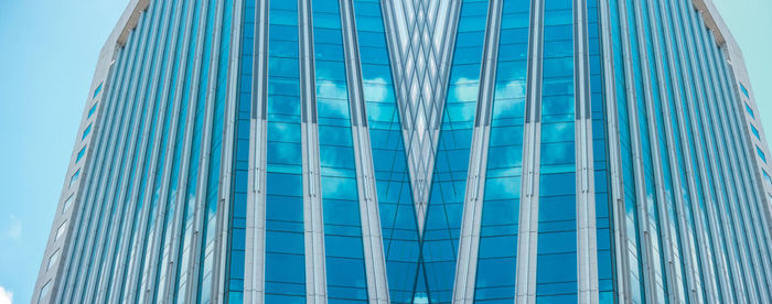 Low angle view of modern glass building against sky