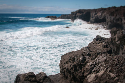 Scenic view of rocks on beach against sky