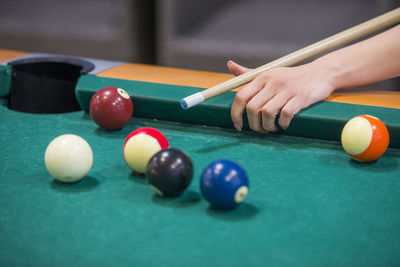 Cropped hand of woman playing pool