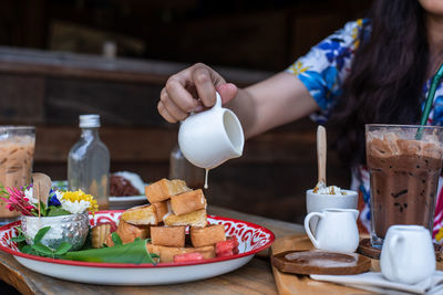 Midsection of woman having food on table