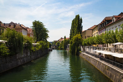 Canal amidst buildings against sky