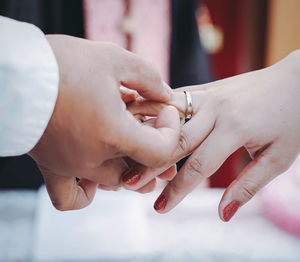 Midsection of couple holding hands