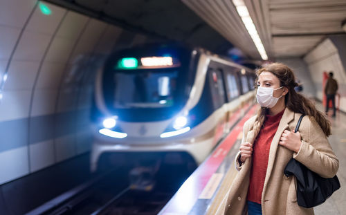 Full length of woman standing in bus