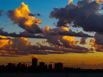 Scenic view of dramatic sky over city during sunset