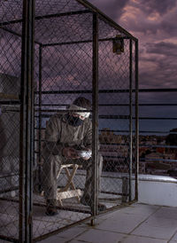 View of fence against cloudy sky