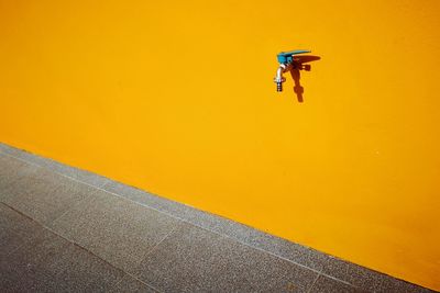 Man riding bicycle on yellow wall