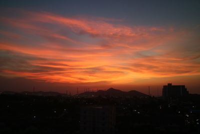 High angle view of silhouette buildings against sky during sunset