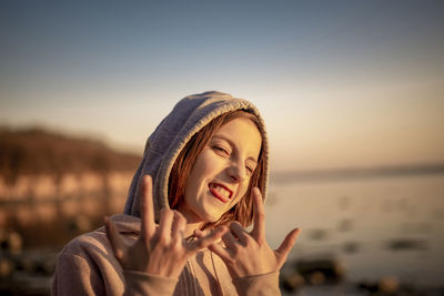 Portrait of woman standing against sky during sunset