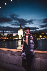 Portrait of man standing at city 8against sky