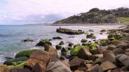 Rocks on beach against sky