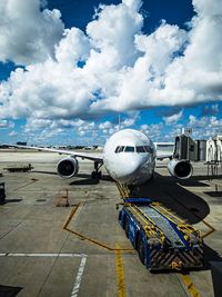 Airplane on airport runway against sky