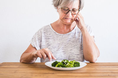 Midsection of woman with ice cream on table