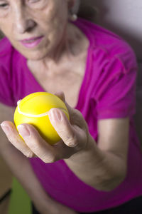 Midsection of woman holding stress ball while sitting at home 