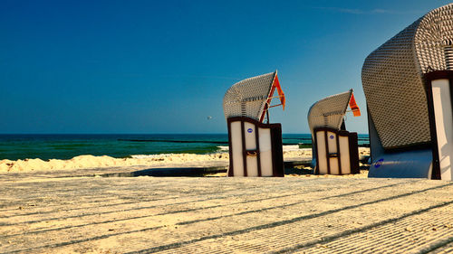 Lifeguard hut on beach against clear blue sky