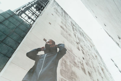 Low angle view of man standing by building