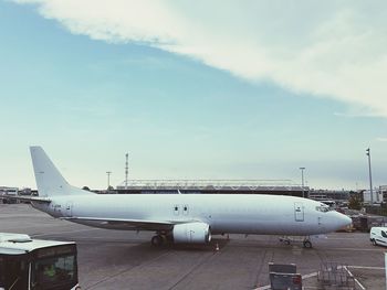 Airplane on airport runway against sky