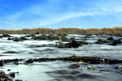 Scenic view of frozen river against sky during winter