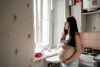 Side view of young woman at home