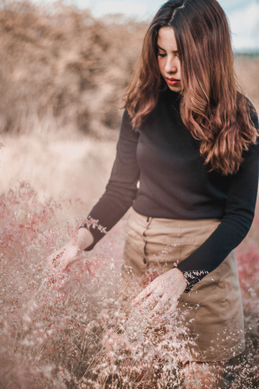 one person, long hair, adult, women, hairstyle, nature, young adult, female, land, brown hair, photo shoot, portrait photography, clothing, spring, landscape, fashion, three quarter length, rural scene, plant, sky, environment, standing, dress, beauty in nature, outdoors, human hair, portrait, casual clothing, lifestyles, brown, redhead, person, red, day, emotion, leisure activity, grass, looking