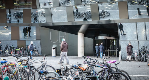 People on bicycle against building in city