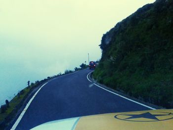 Road amidst trees against sky