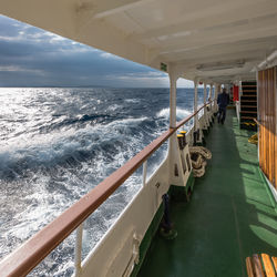 People walking on bridge over sea