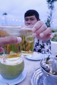 Portrait of man drinking glass on table