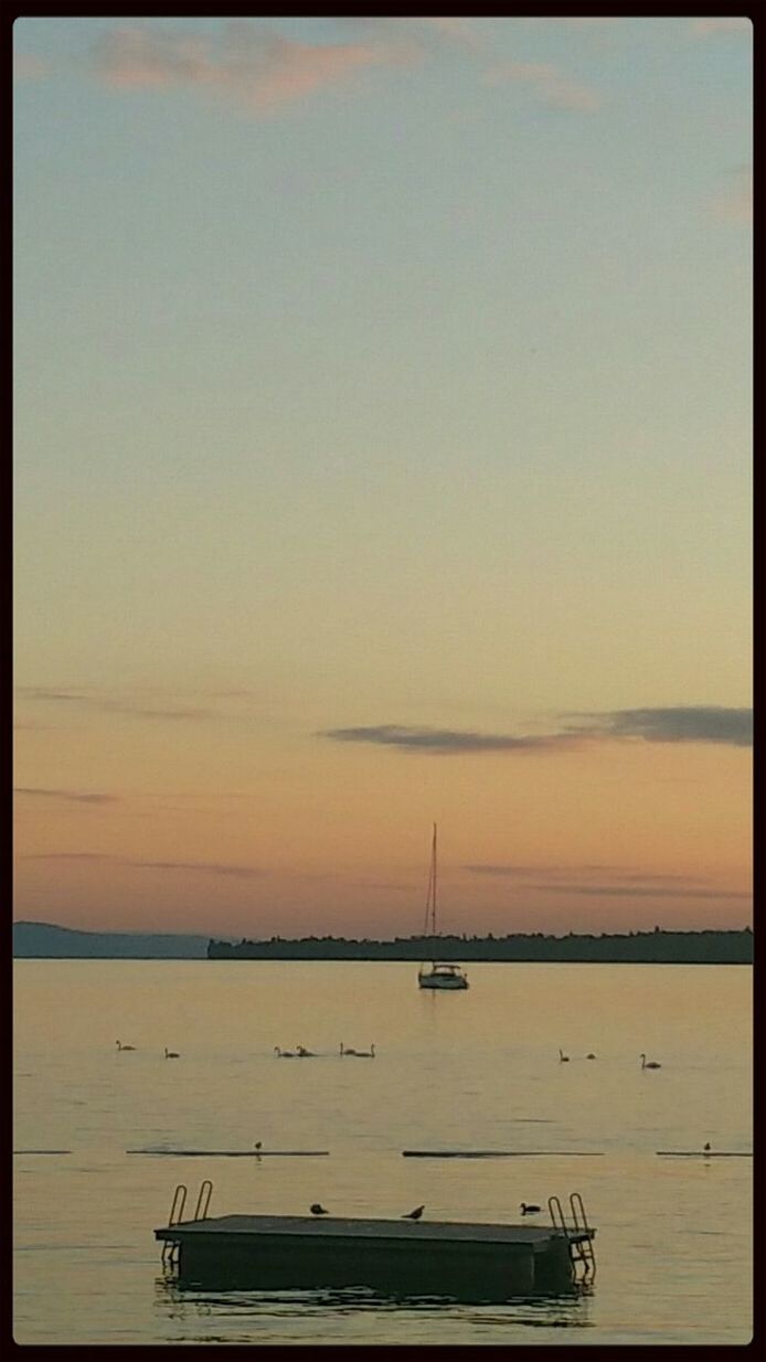 sea, transfer print, water, nautical vessel, horizon over water, transportation, tranquil scene, tranquility, auto post production filter, boat, mode of transport, sunset, scenics, beauty in nature, sky, nature, copy space, clear sky, beach, moored