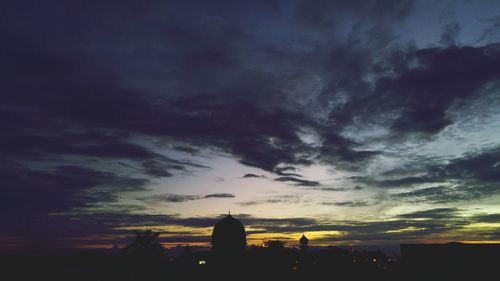 View of cityscape against cloudy sky