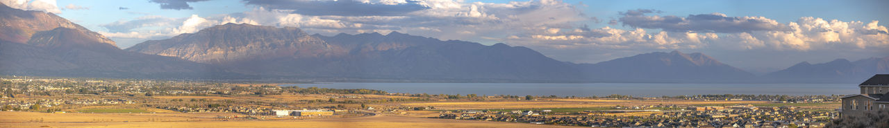 Panoramic view of city by mountains against sky