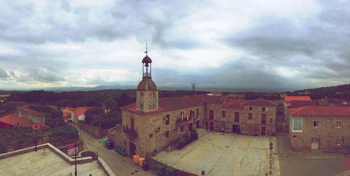 Buildings against cloudy sky