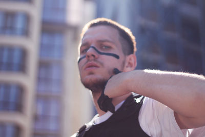 Portrait of young man with face paint in city