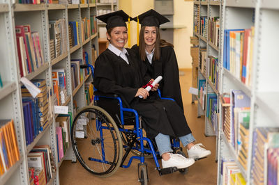 Portrait of smiling young woman standing in library