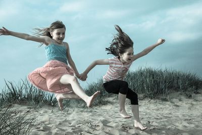 Full length of young girls jumping in mid-air