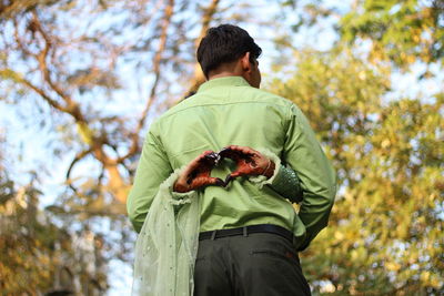 Rear view of man standing against trees during autumn with girl