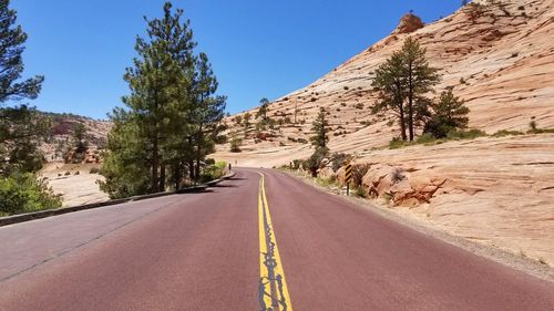 Road amidst mountains against clear sky