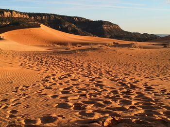 Sand dunes in desert against sky