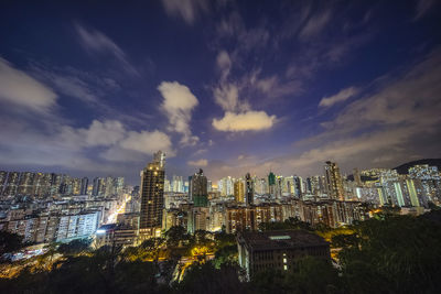 Illuminated buildings in city against sky