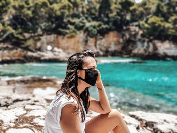 Midsection of woman photographing on beach