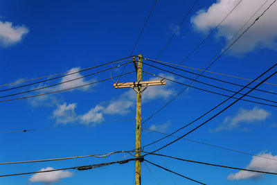 Low angle view of telephone line against blue sky