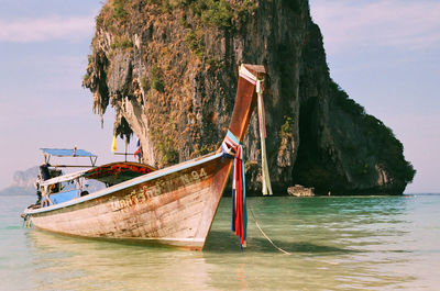 Boat moored on sea against mountain