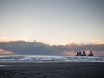 View of calm beach against scenic sky