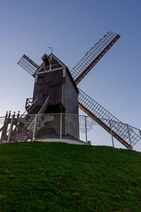 Traditional windmill on field against clear sky