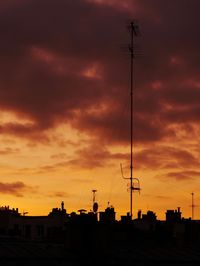 Low angle view of silhouette buildings against orange sky