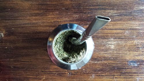 Directly above shot of yerba mate in container on wooden table