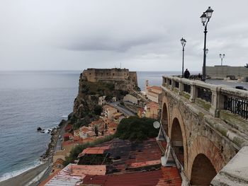 Buildings by sea against sky in city